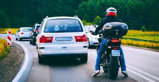 A car and motorcycle sharing the road safely, illustrating the importance of awareness and space for motorcyclists.