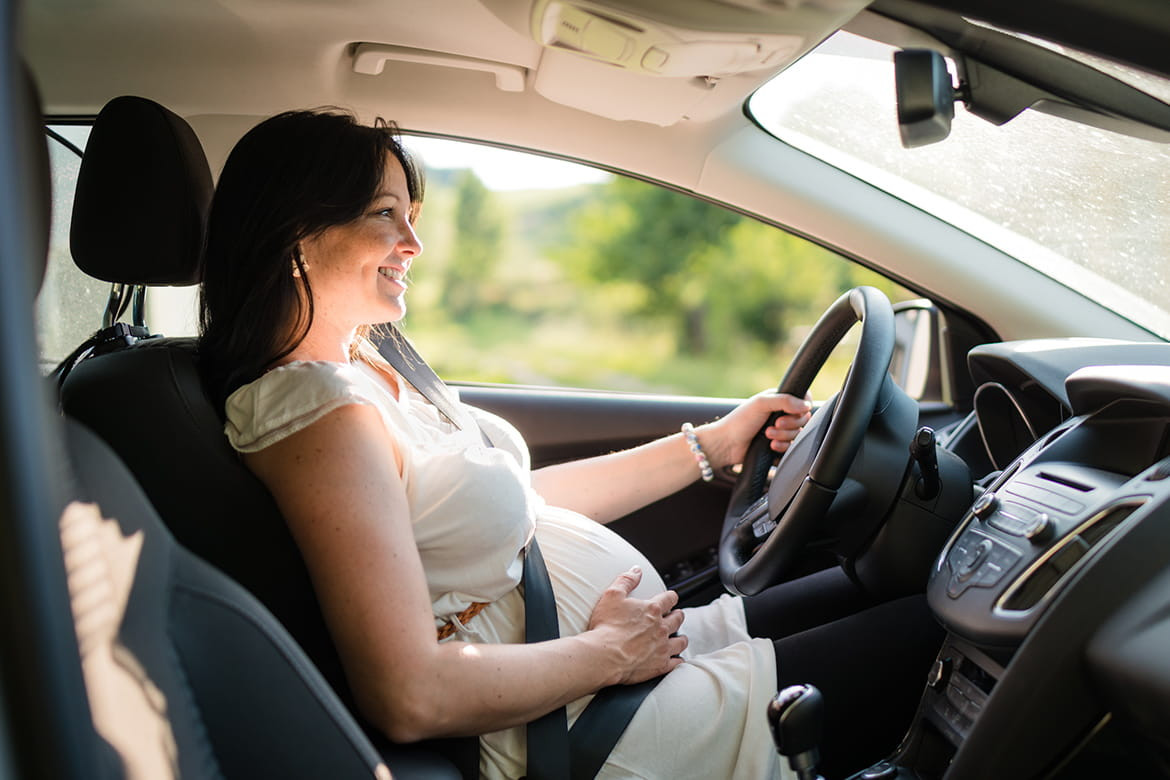 Pregnant Woman Adjusting Car Seat for Safe Driving