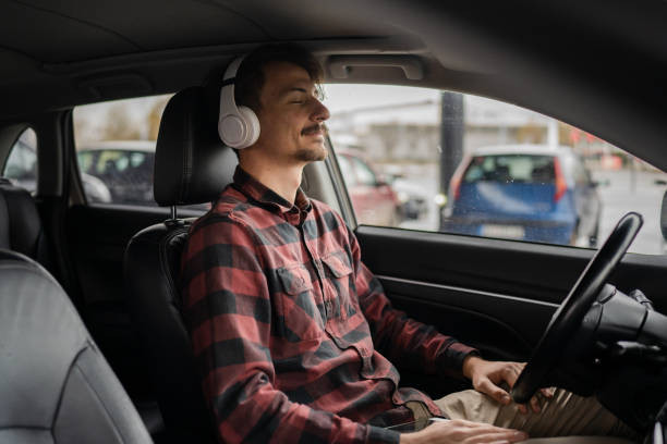 Driver enjoying music while driving and maintaining focus on the road.