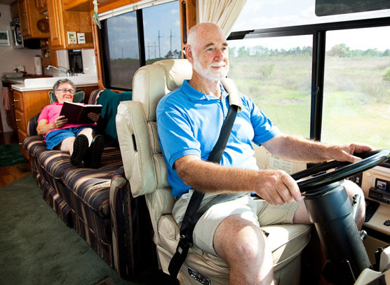 An RV parked on the open road with a driver preparing to take a trip, showcasing the type of driver's license needed to operate an RV.