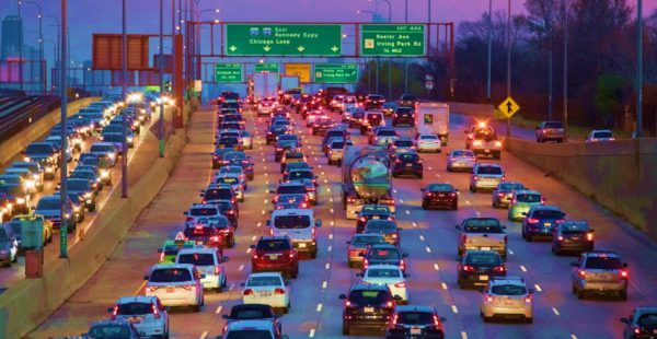 Aerial view of cars stuck in heavy traffic on a freeway in a California city, highlighting traffic congestion in busy urban areas.