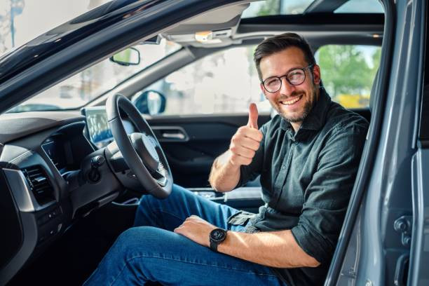 A young driver adjusting a dash cam in their car, surrounded by various car gadgets and accessories for a safe and comfortable drive.