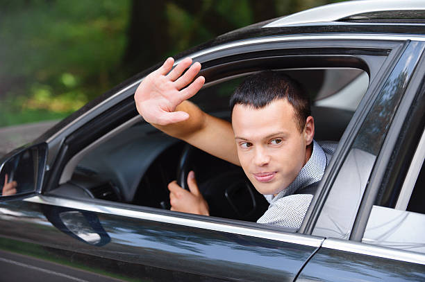 A driver using a turn signal while practicing driving etiquette on the road