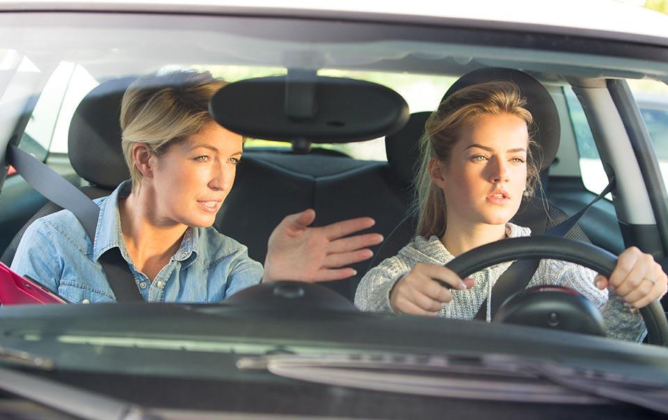 Young, responsible driver proudly holding a new license, educated by Get Drivers Ed.