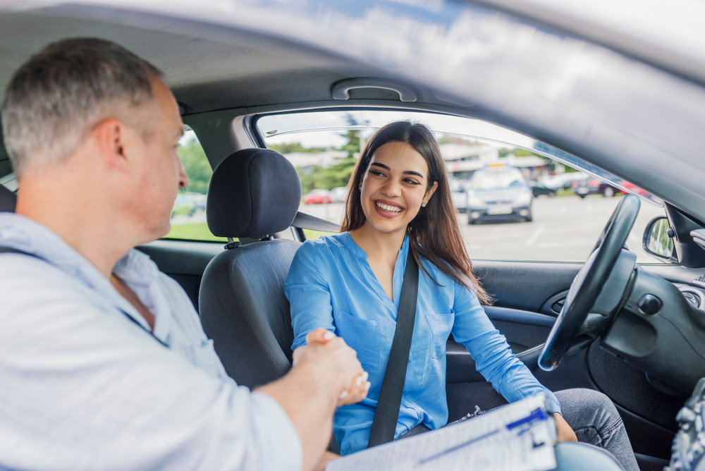 A teen driver proudly holding a license, a milestone achieved through Get Drivers Ed's 'drivers ed' program.