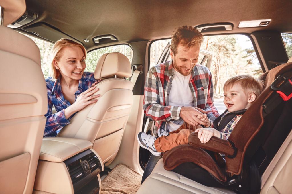 Careful parent adjusting a baby car seat, following safety advice from Get Drivers Ed.