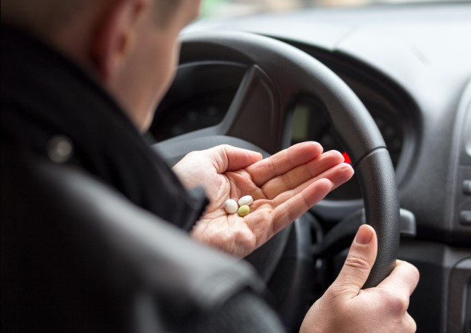 Image of a driver looking concerned with medication bottles in the foreground.