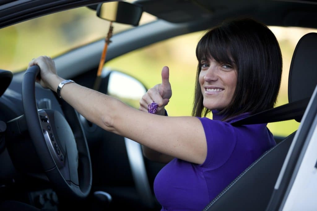 A confident new driver, with the "Get Drivers Ed" interface on a screen beside them.