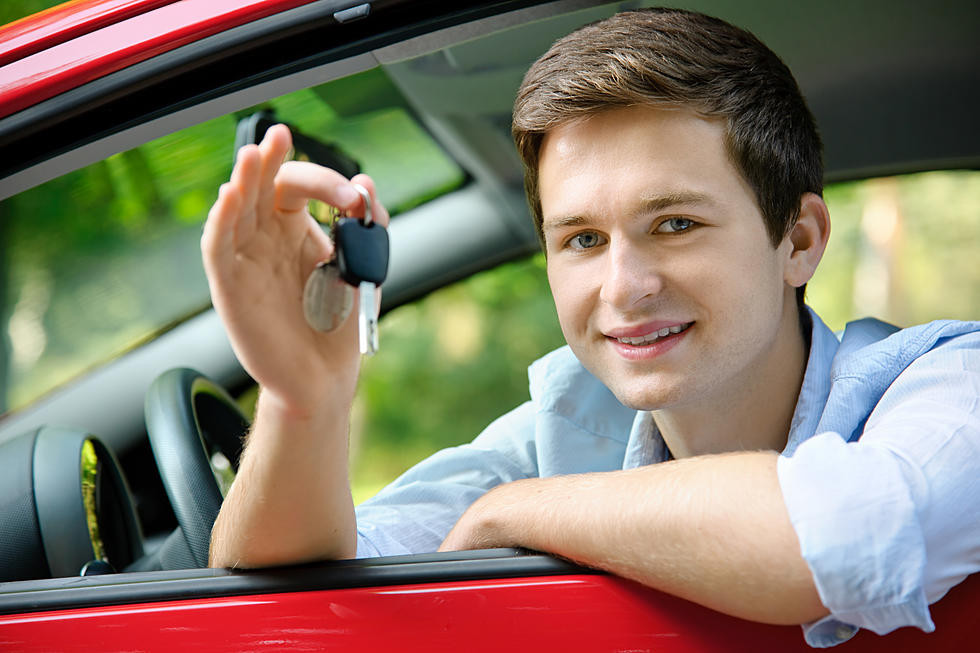 A Texas teen proudly showcasing their new driver's license with a "Get Drivers Ed" backdrop.