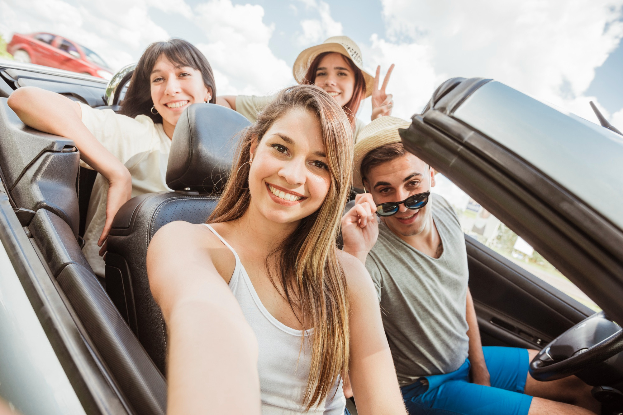 Teenagers happily driving in a car, representing newfound independence.