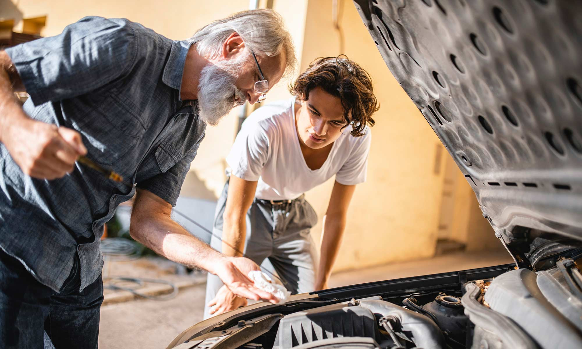 A person checking their car's oil level as part of a DIY maintenance routine