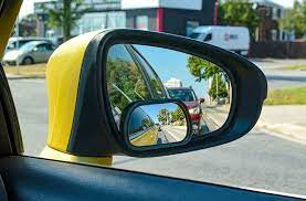 A driver checking blind spots over their shoulder before making a lane change, practicing safe driving techniques from Get Drivers Ed.