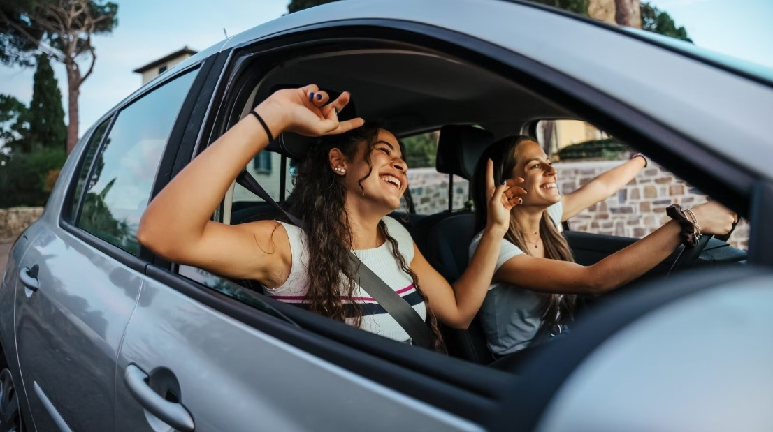 A driver adjusting the radio while driving, illustrating how music can cause distracted driving if not managed properly.