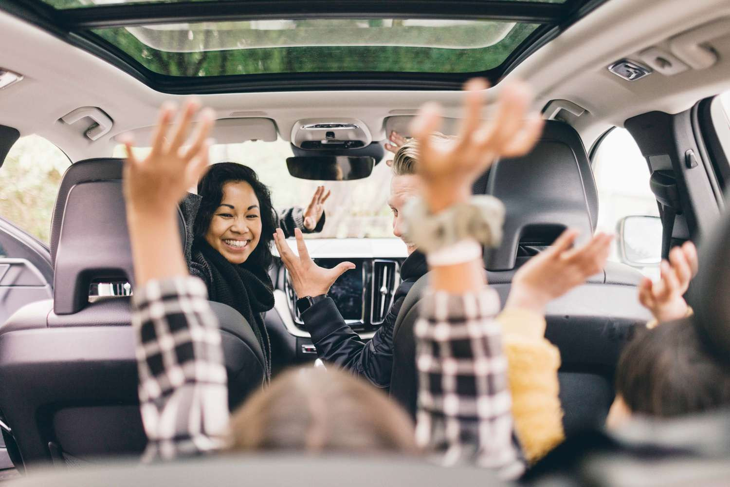 Family enjoying a road trip with gadgets and games, with a focus on safe and fun driving.