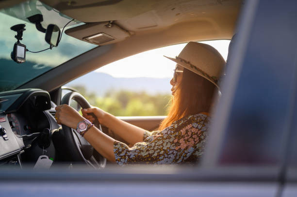 driver staying alert on a long-distance drive, with hands on the wheel, a water bottle nearby, and the sun shining through the windshield.