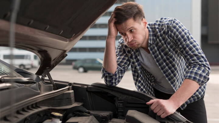 A mechanic inspecting a car engine for common issues.