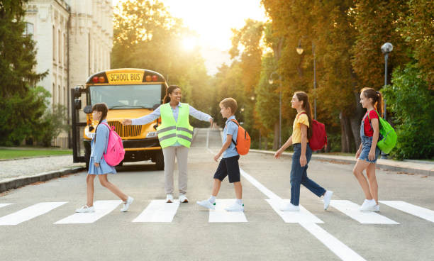 "Driver cautiously navigating through a school zone with children crossing the street"