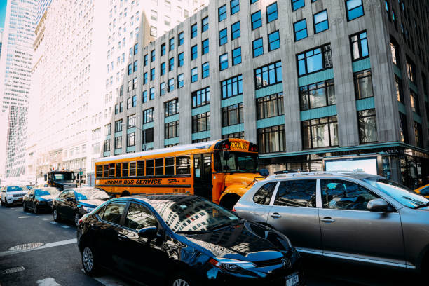 "Driver carefully following a school bus with flashing stop sign extended"