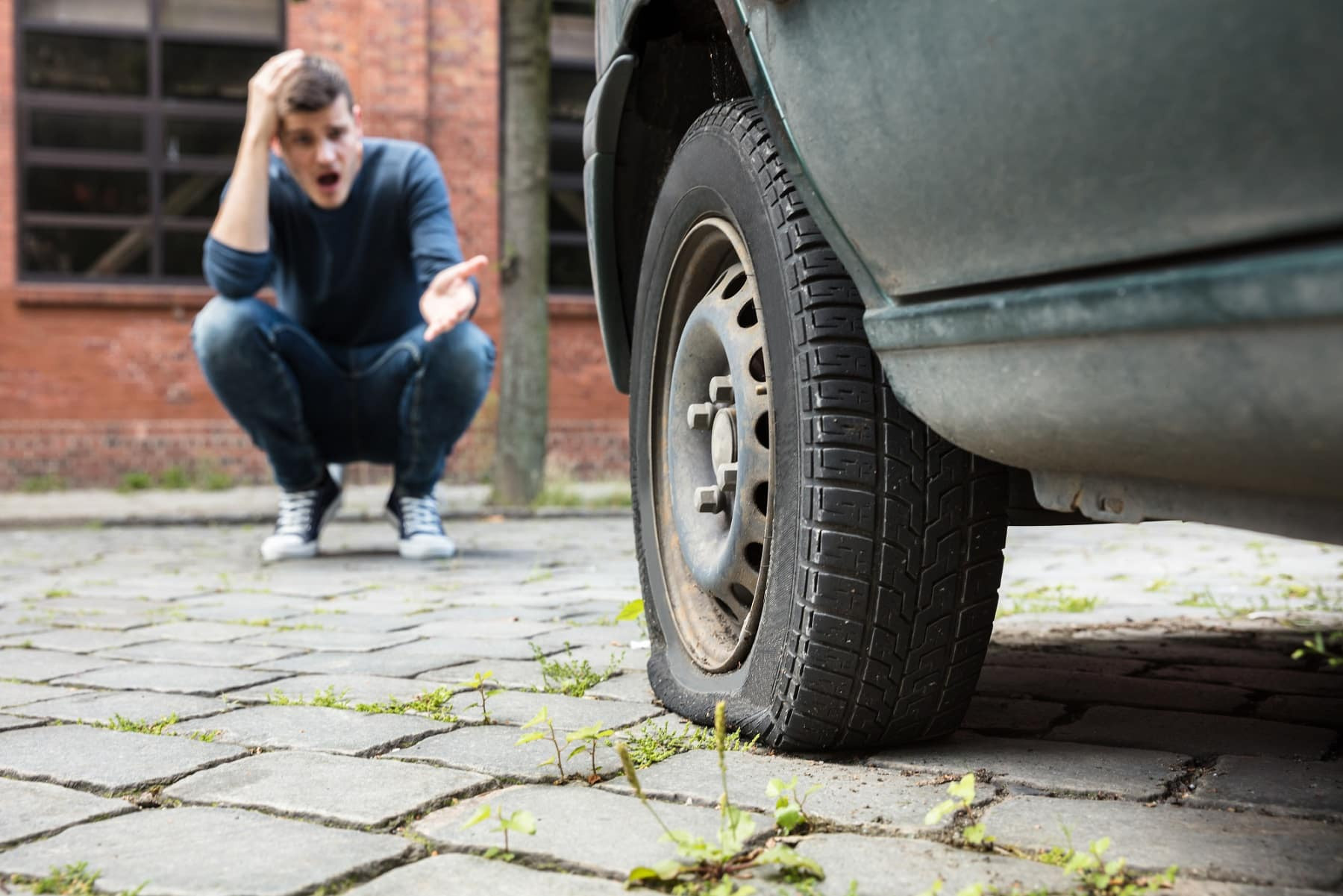 A car on the highway with a blown-out tire, emphasizing the need for safety measures