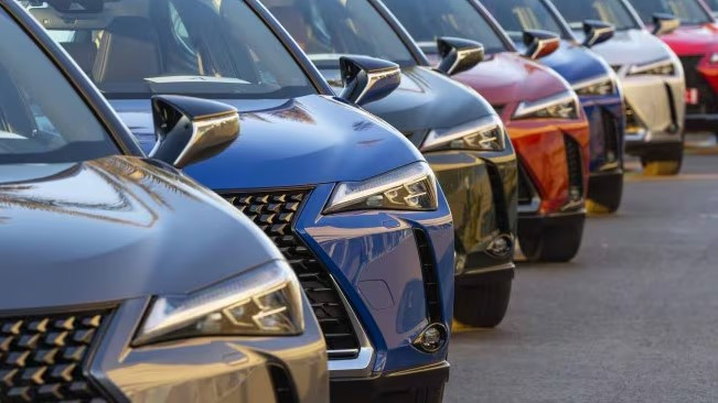 A row of brightly colored cars parked side by side, showing popular car colors that are both safe and stylish for new drivers.