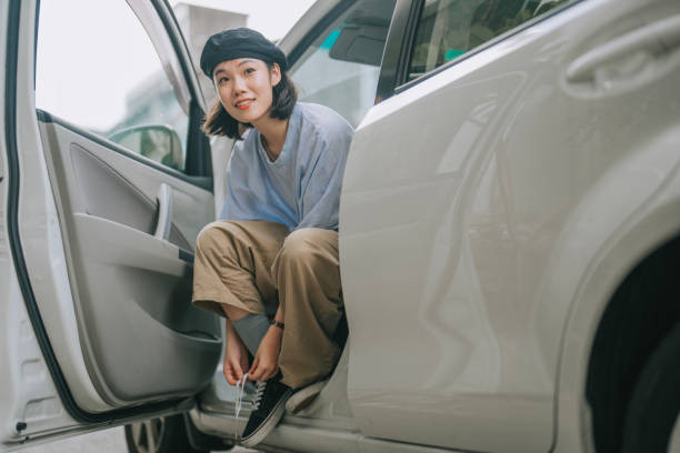 A new driver confidently driving on the road, focusing on building skills and safety during their first 100 miles behind the wheel.