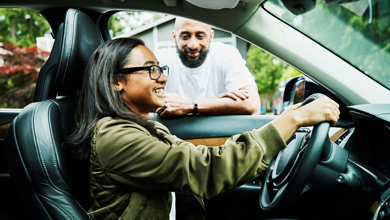 A teenager confidently driving a car with a supportive instructor from Get Drivers Ed, highlighting the importance of comprehensive driver education.