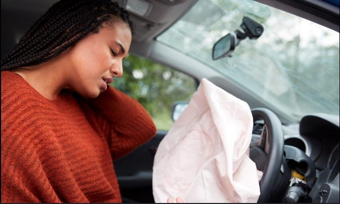 Close-up of a deployed airbag in a car, illustrating the importance of airbag safety and maintenance for driver protection.