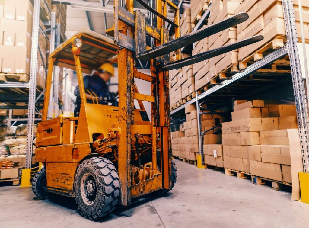 A certified forklift operator safely handling a load, showcasing the importance of forklift training and certification.