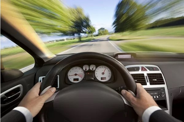 A worried driver looking at a car insurance bill, symbolizing how bad driving can increase financial stress and affect credit scores.