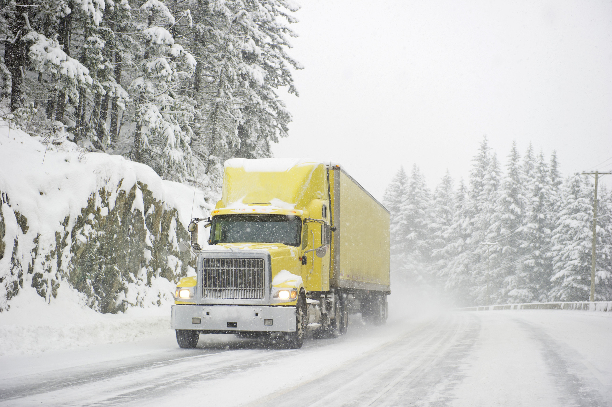 A truck driver navigating through rainy weather, highlighting safe driving practices and preparation for different weather conditions.