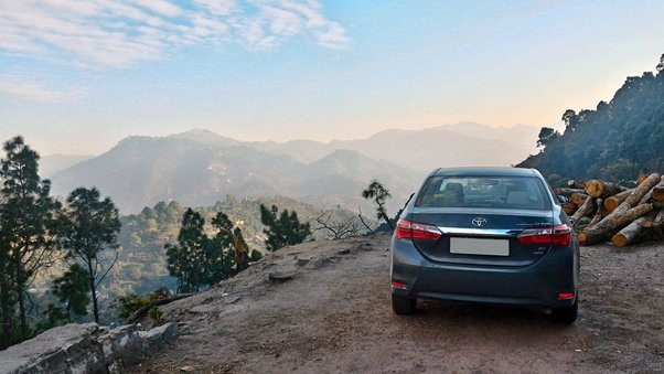 Car driving safely on a winding mountain road, following tips from Get Drivers Ed