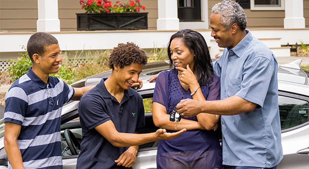 A parent and teen practicing driving together on a road.