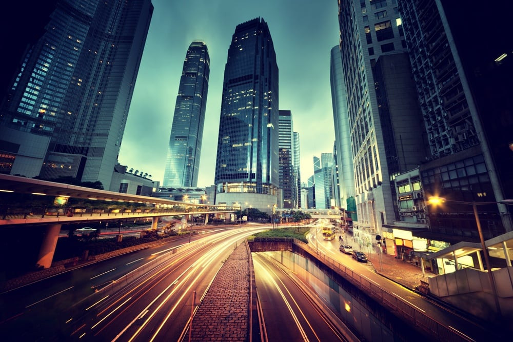 A car navigating heavy city traffic with tall buildings in the background, representing safe driving practices in urban environments.