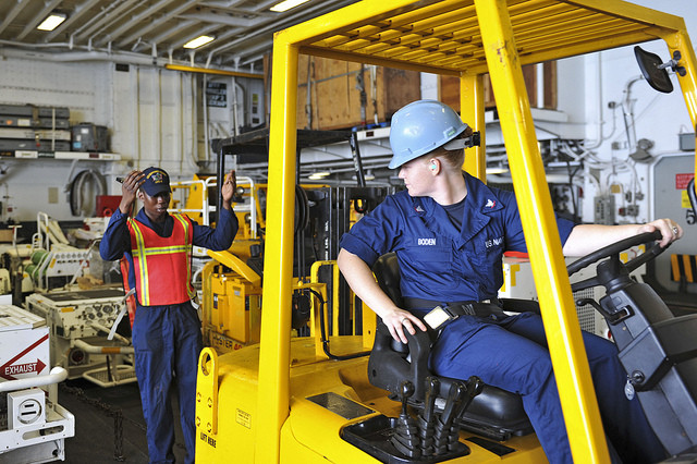 A forklift operator safely maneuvering a load in a warehouse, showcasing essential driving tips for forklift safety and efficiency.