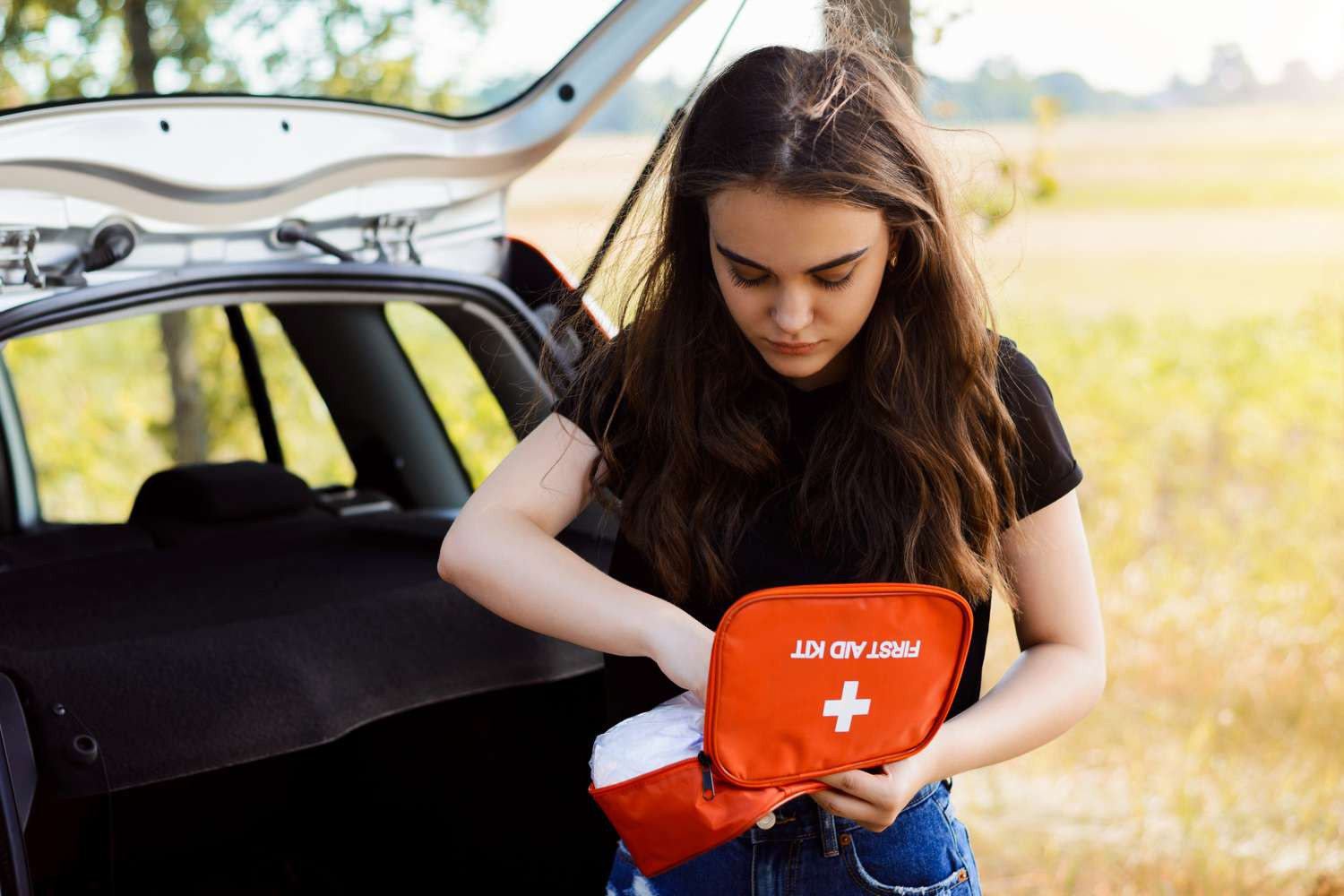 A car first aid kit opened, revealing 6 essential items every driver should have, endorsed by Get Drivers Ed for drivers ed preparedness.