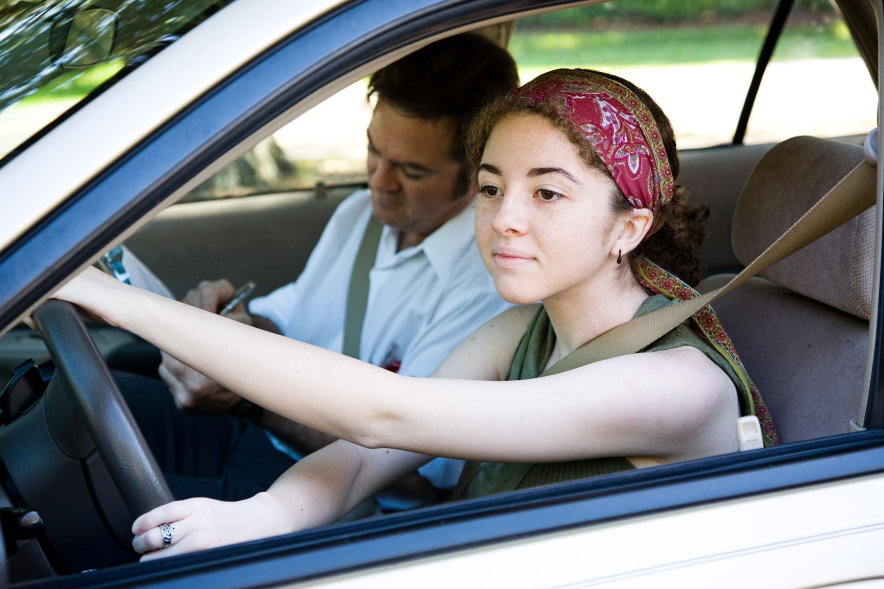 Student driver practicing driving maneuvers during a Get Drivers Ed lesson, focusing intently on the road ahead.