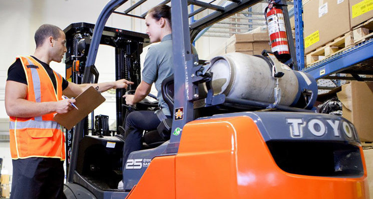 A certified forklift operator safely handling a load, highlighting the benefits of enrolling in a forklift certification course.