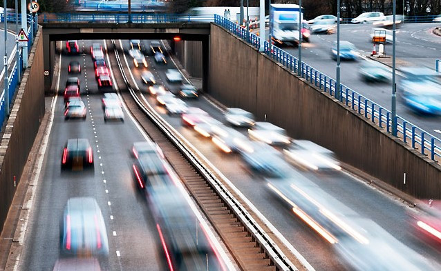 A driver safely changing lanes on a busy highway, illustrating the importance of checking blind spots and signaling.