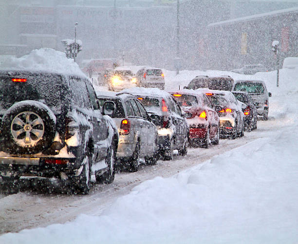 "Car driving safely on icy road with snow-covered landscape"