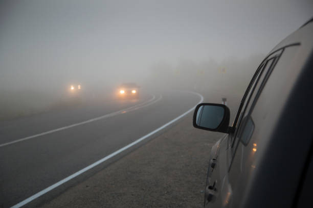 "Car driving in low visibility conditions with fog and smoke"