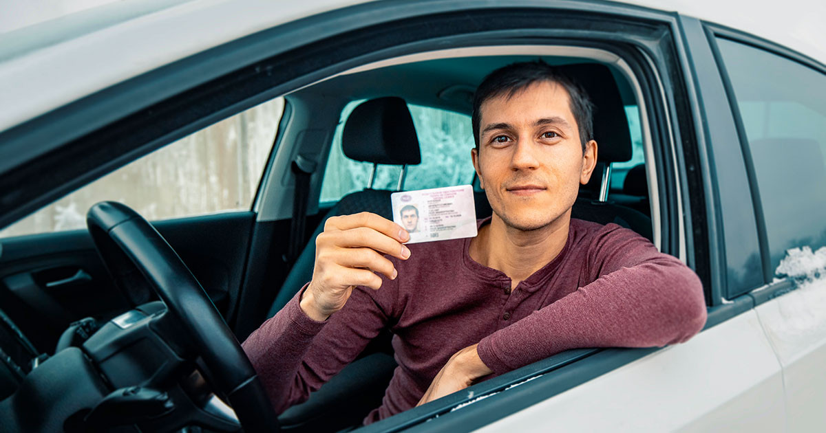 A confident adult driver holding an Illinois driver’s license after completing the required steps with guidance from Get Drivers Ed.